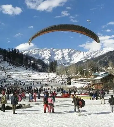 Paragliding over the snowy slopes of Solang Valley