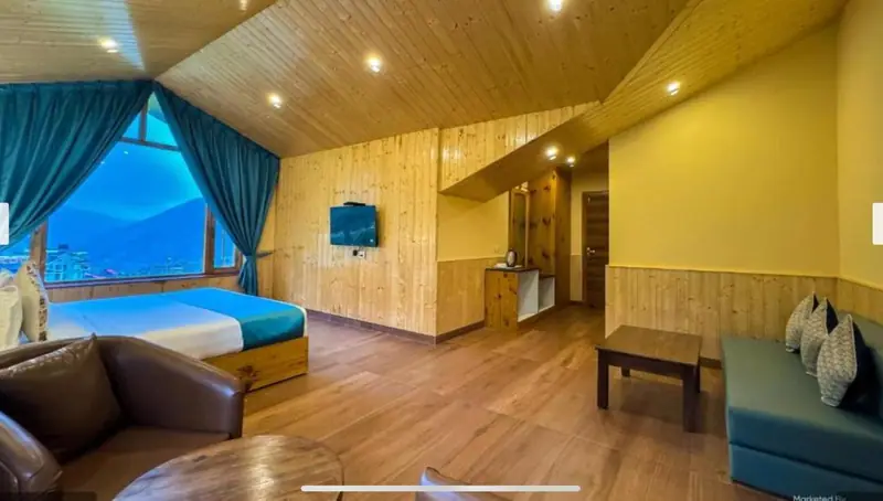 Spacious room with sofa and a large window facing the valley