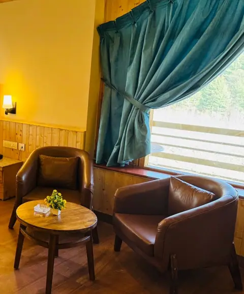 Sitting area with armchairs and a window in a room at Dashaur Heights